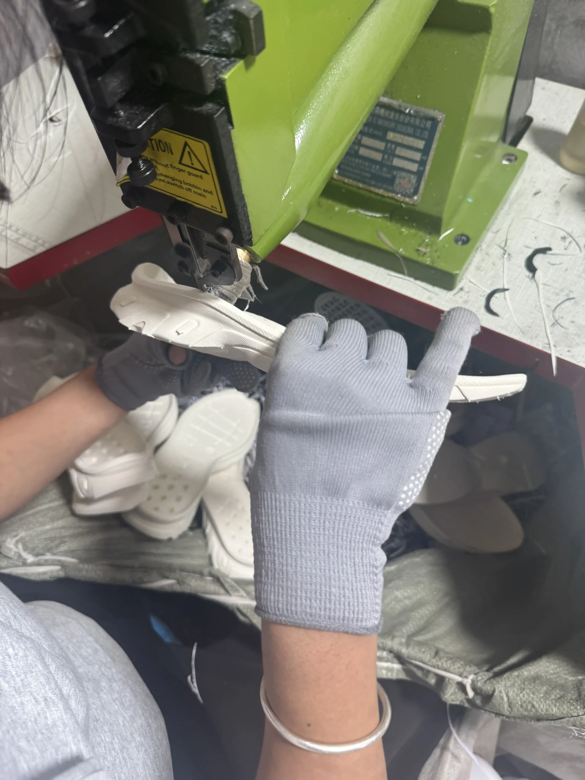 Worker trimming excess material from a molded shoe sole