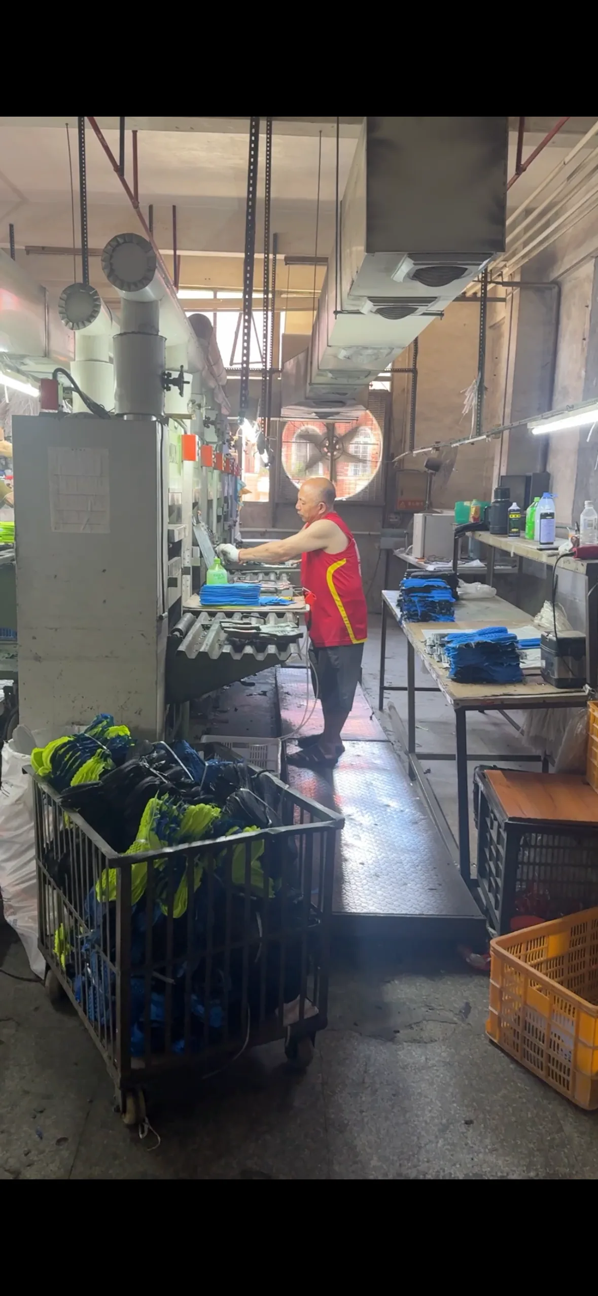 Factory operator working at a sports sole molding machine