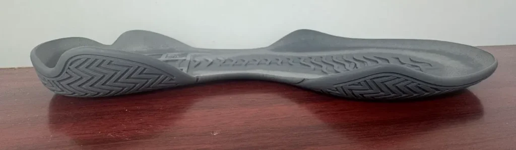 Gray rubber boxing shoe outsole shown from the side, with tread wrapping around the forefoot and heel